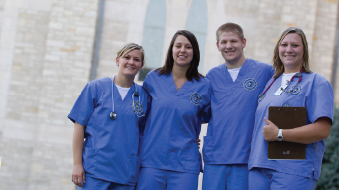 Four nursing students standing in front of Bishop Marty Memorial Chapel