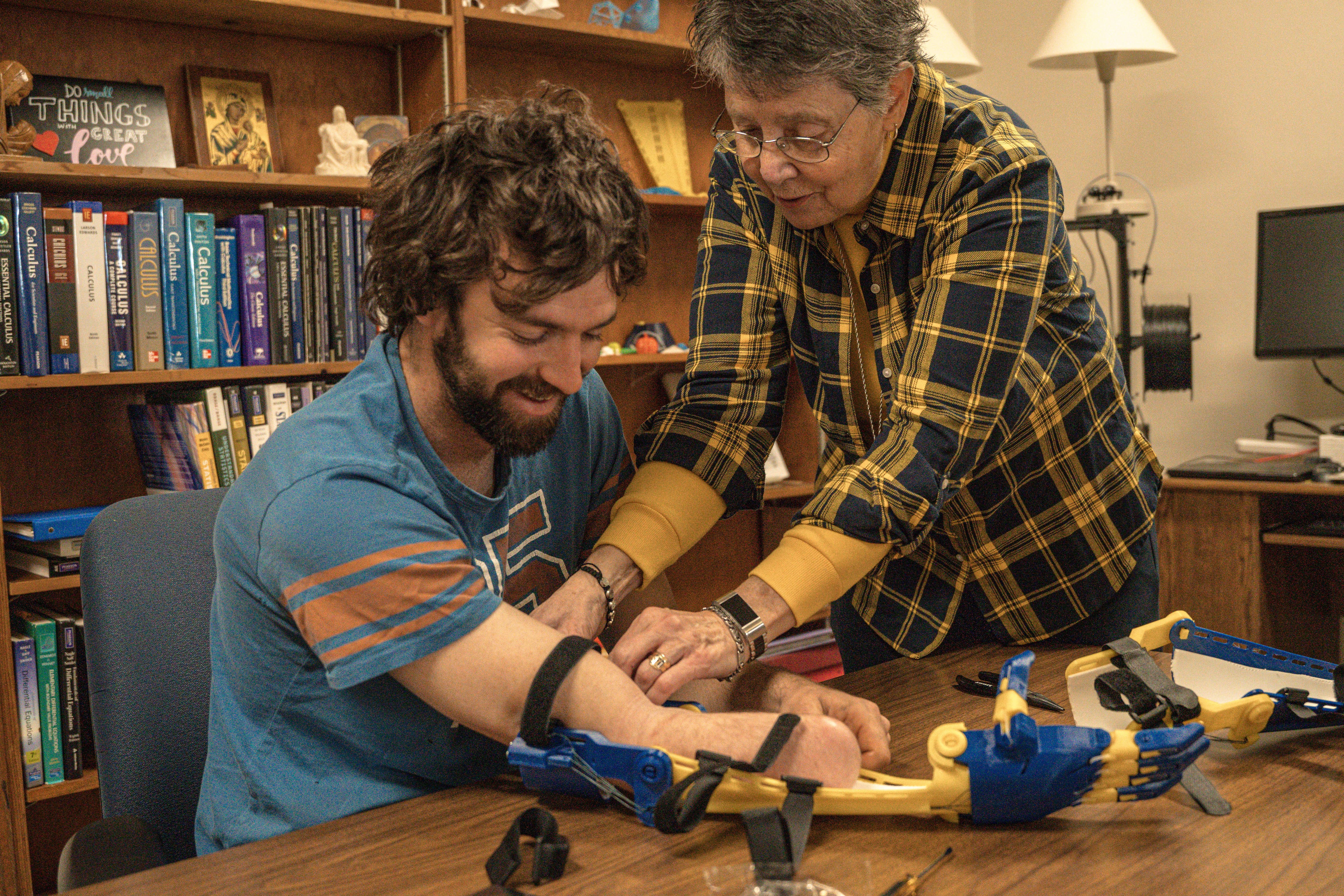 Sr. Bonita helps Trask adjust his new arm prosthetic